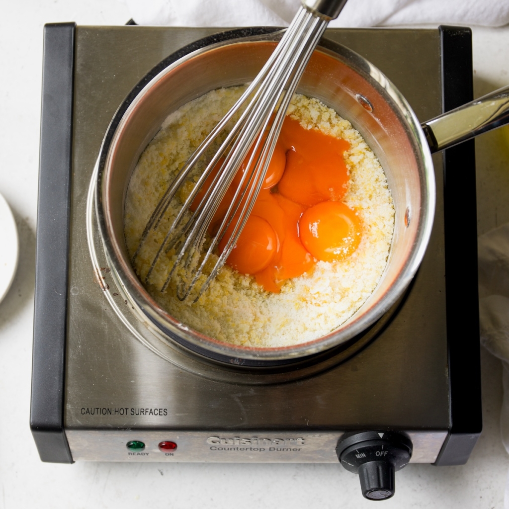 Whisking the eggs into the sugar and zest and in saucepan.