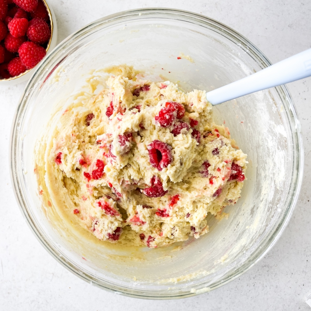 A glass bowl with lemon raspberry muffin batter.