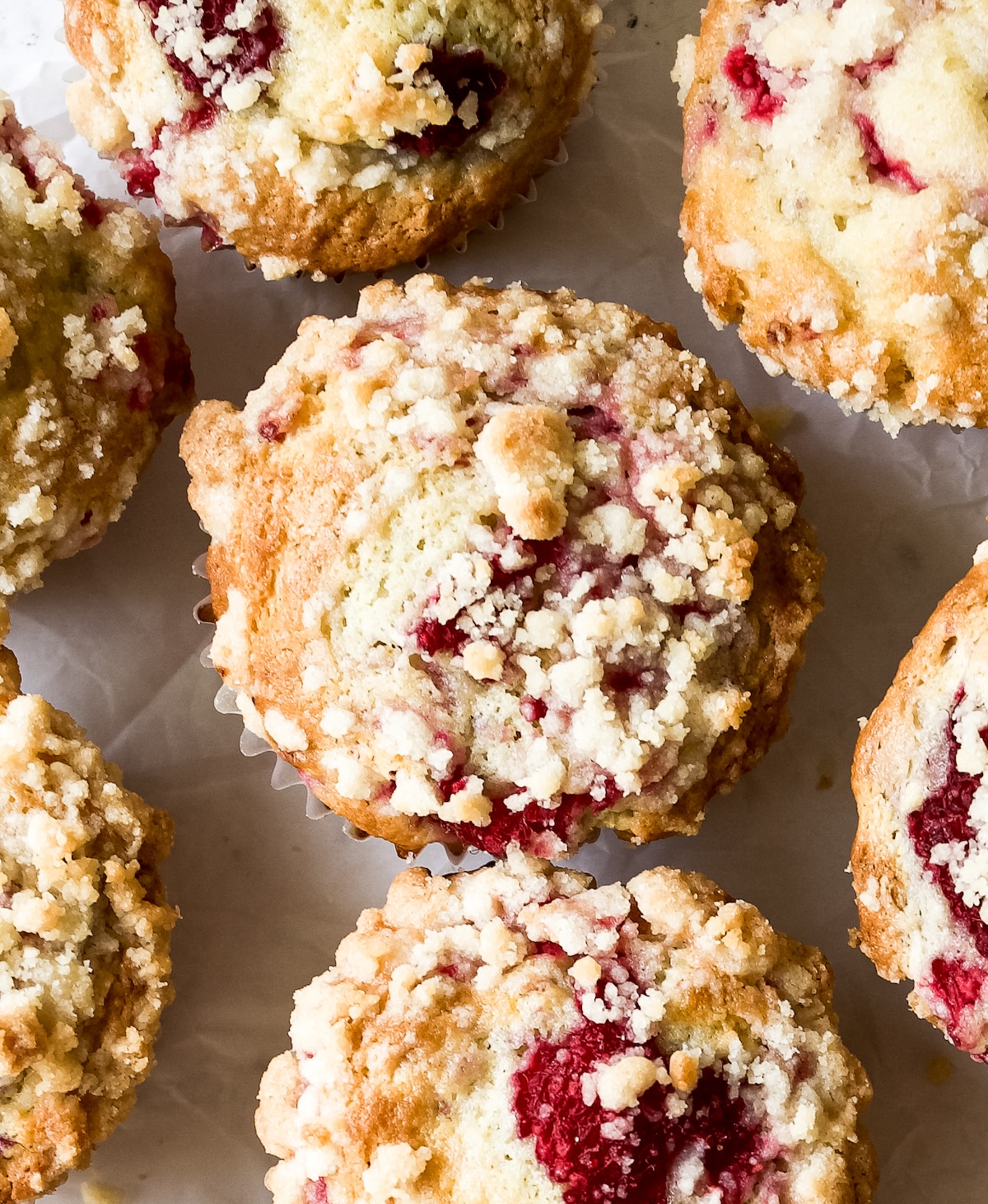 A close up overhead shot of streusel raspberry muffins.