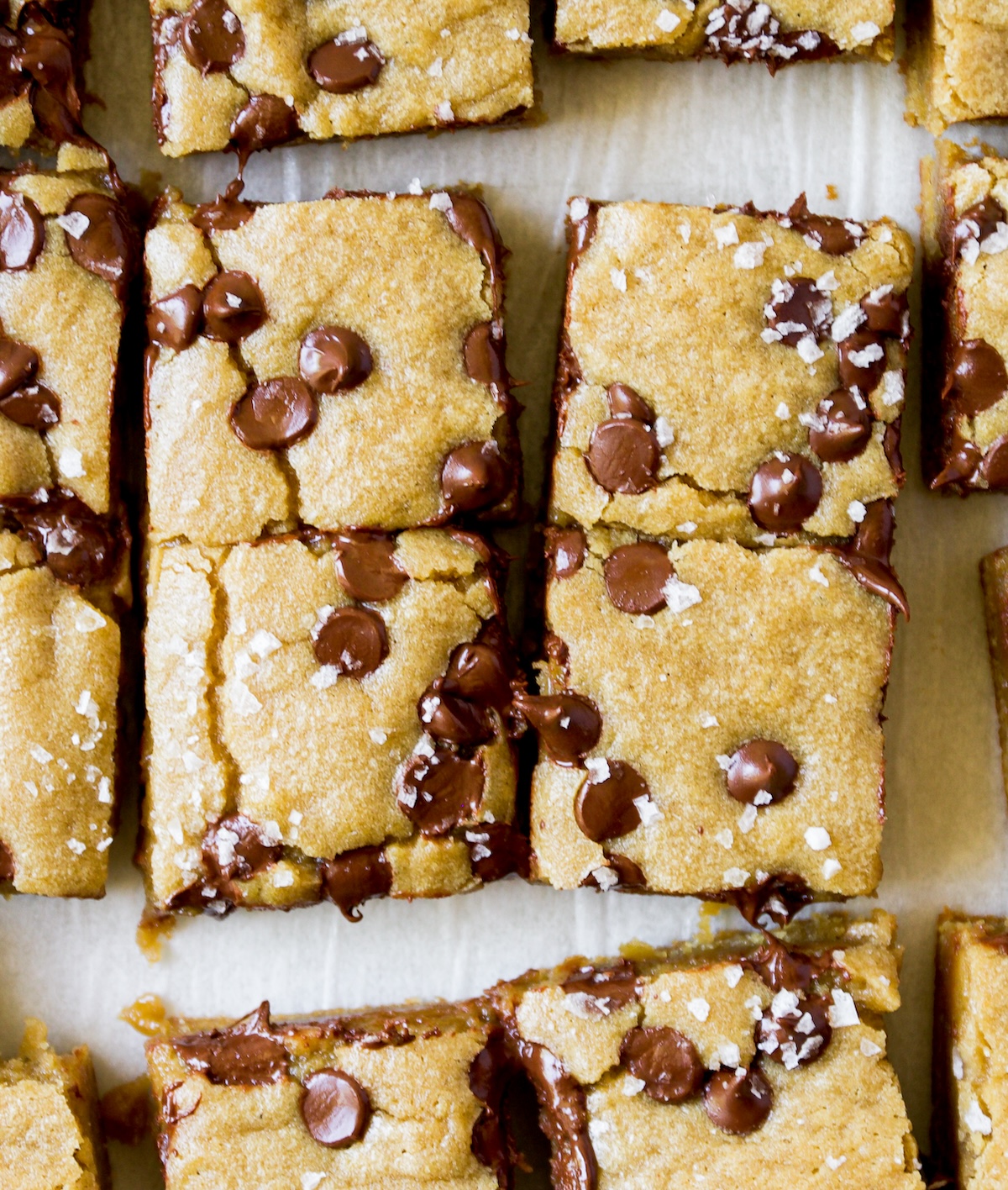 A close up of brown butter blondies on a white surface.
